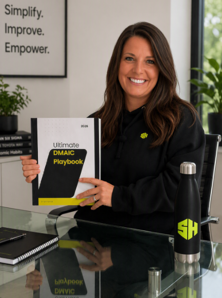 Sam holding the Ultimate DMAIC Playbook at her desk