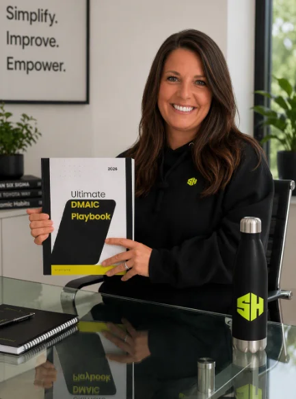 Sam holding the Ultimate DMAIC Playbook at her desk
